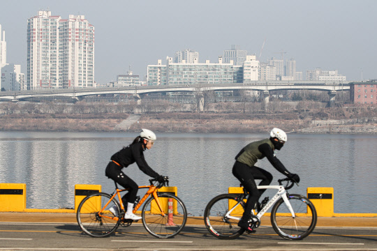 대기 정체로 전국의 미세먼지와 초미세 먼지가 '나쁨'을 기록 중인 13일 오전 서울 송파구 잠실 한강시민공원을 찾은 시민들이 자전거를 타고 있다. 환경부는 14일까지 미세먼지 고농도 상황이 지속될 수 있다며 최대한 야외활동을 자제하는 등 국민행동요령을 준수해 달라고 당부했다. <연합뉴스>